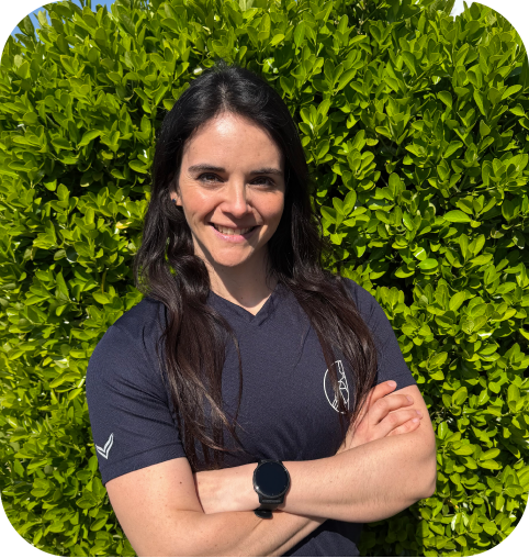 Lorena Montenegro: Junge Frau mit schwarzen langen Haaren, dunkelblaues T-Shirt mit Logo der Praxis und verschränkten Armen